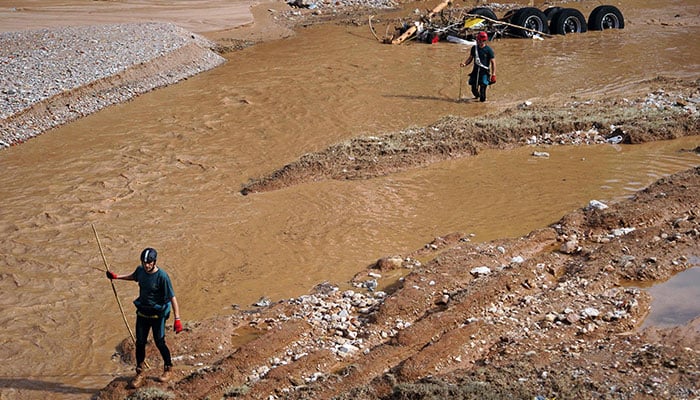 Two Civil Guard rescuers search a river following the devastating effects of flooding on the town of Paiporta, in the region of Valencia, eastern Spain on November 1, 2024. — AFP