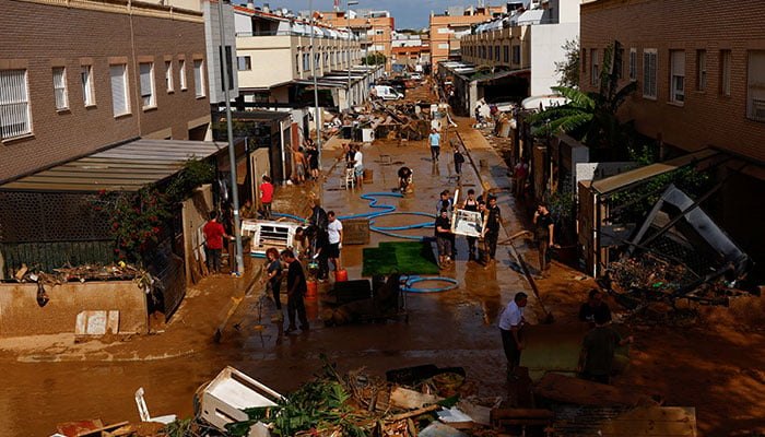 People clean up a mud-covered street after heavy rains in Alfafar, in Valencia, Spain, November 1, 2024. — Reuters