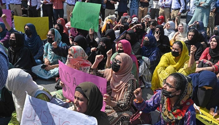 Students carry placards as they shout slogans during a protest in Lahore on October 15, 2024. — AFP