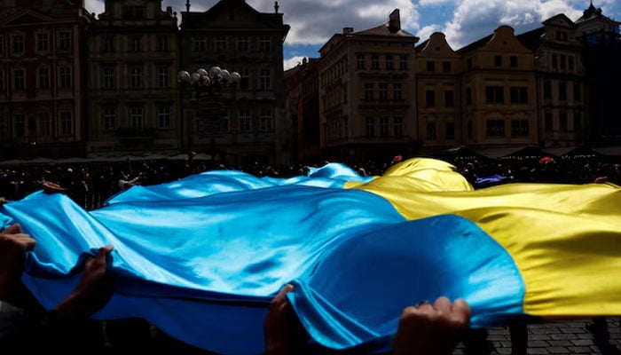 People hold a Ukrainian flag during a rally in support of Estonias military strategy plan to help Ukraine, in Prague, Czech Republic, April 21, 2024. — Reuters