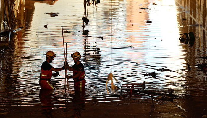 Firefighters wade in water as they search for victims under a bridge, in the aftermath of heavy rains that caused floods, in Alfafar, near Valencia, Spain, November 2, 2024. — Reuters