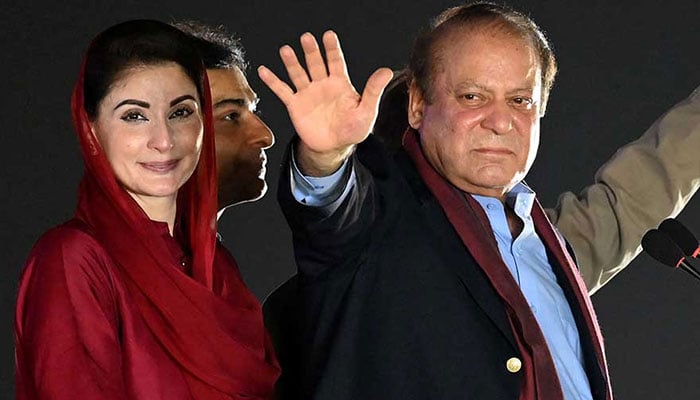 Former prime minister Nawaz Sharif (R) stands beside his daughter Maryam Nawaz (L) as he waves to his supporters gathered at a park during an event held to welcome him in Lahore on October 21, 2023. —AFP