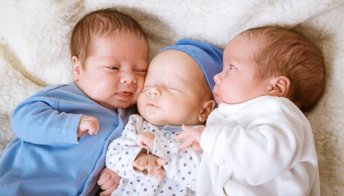 A representational image shows three babies together. — Pexels