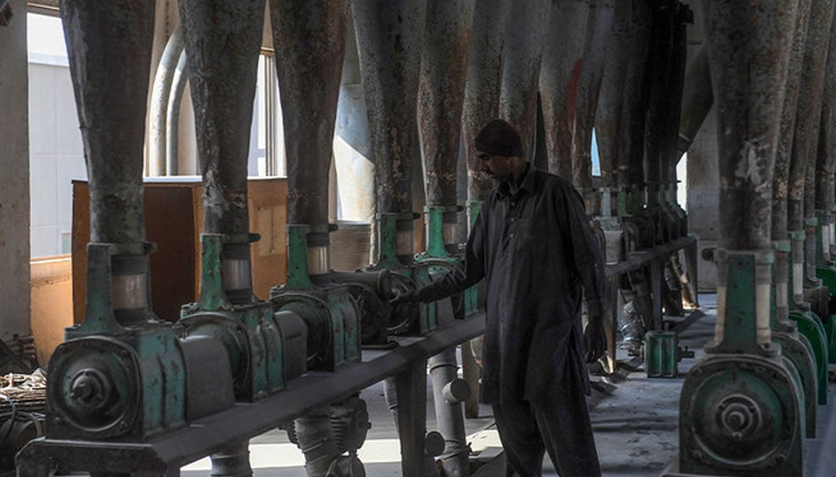 A worker monitors the wheat grind process turning it into flour at a mill in Karachi on January 21, 2020.  — AFP