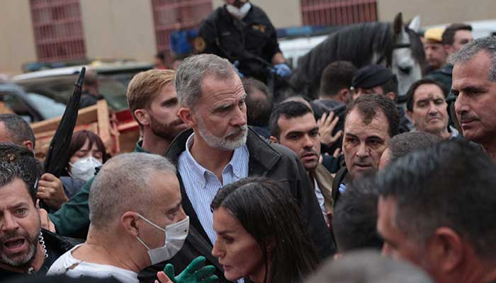 Spains King Felipe and Queen Letizia react with mud on their faces as they listen to people during their visit to the areas affected by floods, in Valencia, November 3, 2024. — Reuters