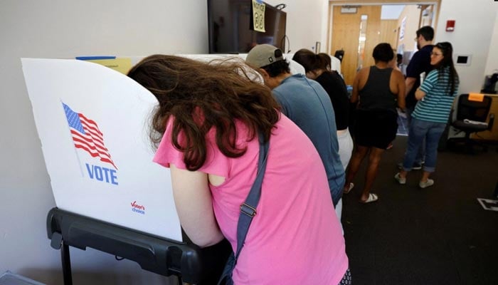 A voter leans into a booth while filling out her ballot form during midterm elections in Chapel Hill, North Carolina, November 5, 2022. — Reuters