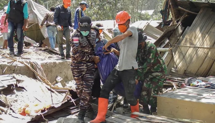 Members of a rescue team carry away body bags containing deceased people at Klatanlo village, in East Flores after Mount Lewotobi Laki-Laki erupted overnight. — AFP