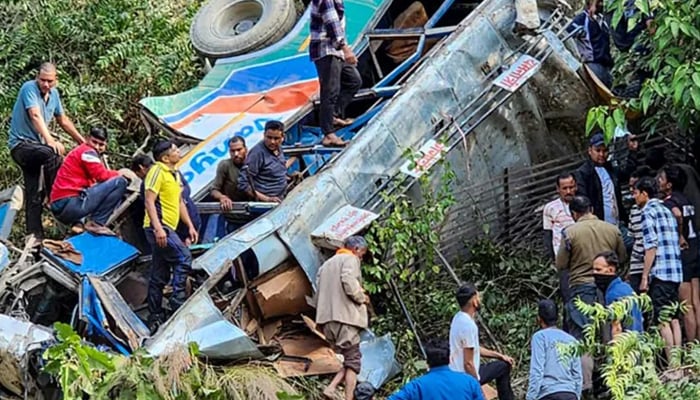 This handout photograph shows people at the site of a bus accident after it fell into a gorge at Almora district in Indias Uttarakhand state on November 4, 2024. — Reuters