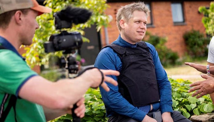 Far-right politician Rasmus Paludan sits outside the prohibition zone, as according to local media, he is being ordered by the Bornholm Police to not participate in the Folkemodet festival in Allinge, on the island of Bornholm, Denmark, June 15, 2023. — Reuters