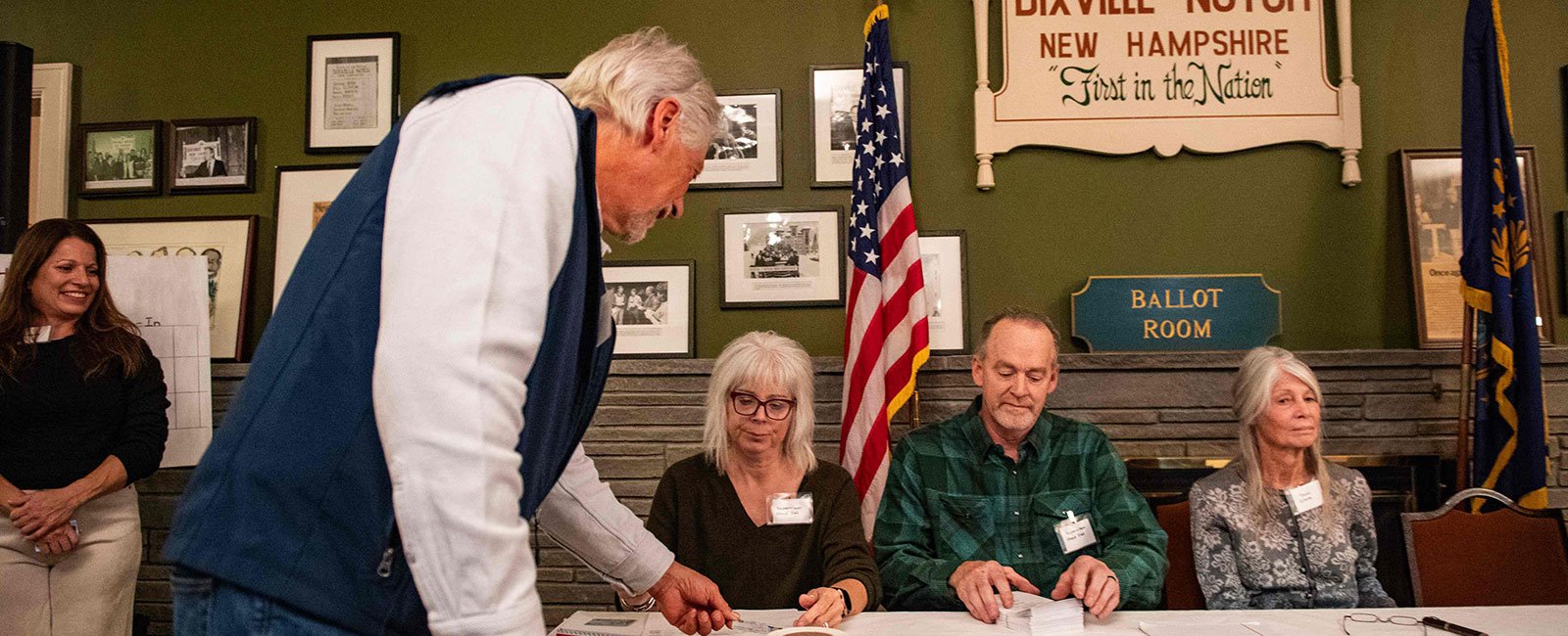 A Dixville Notch resident shows his ID as he signs in to cast his vote in the US election at midnight in the living room of the Tillotson House at Balsams Grand Resort, marking the first votes in the US election, in Dixville Notch, New Hampshire on November 5, 2024. - AFP