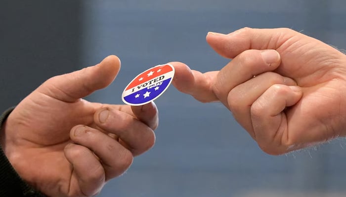 A voter receives a sticker after casting their ballot at New Begin Hall in Maine's 2nd Congressional District in Gray, Maine. – Reuters