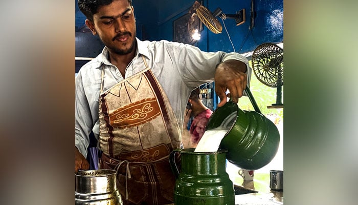 Abdul Qadir mixes milk in chai as its brews on the stove. — Photo by author