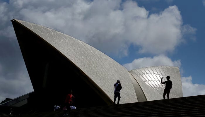 Tourists take photographs with their mobile phones in front of the Sydney Opera House in Sydney, Australia, October 14, 2018. — Reuters