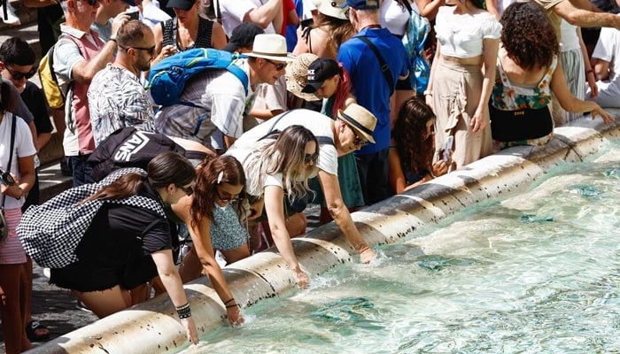 People cool themselves at the Trevi Fountain during a heatwave across Italy in Rome, Italy, July 20, 2023. — Reuters