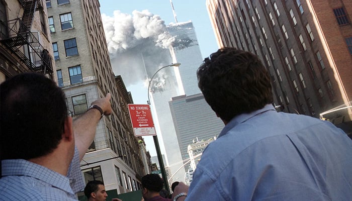 Pedestrians react to the World Trade Center collapse, September 11, 2001. — Reuters