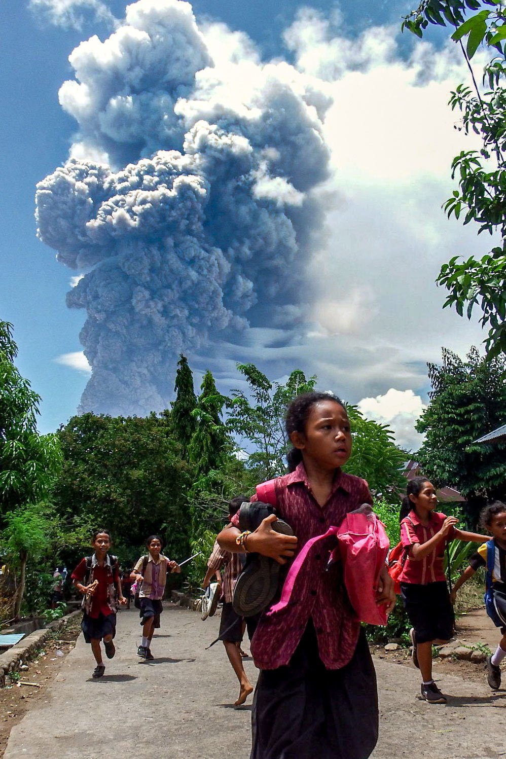 Schoolchildren run during the eruption of Mount Lewotobi Laki-Laki, as seen from Lewolaga village in East Flores, East Nusa Tenggara on November 7, 2024. — AFP