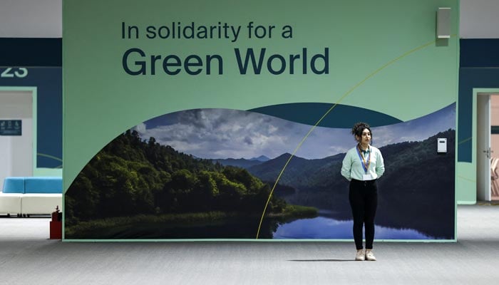 A participants stands next to a board at the venue of the United Nations climate change conference, known as COP29, during a media tour ahead of the summit beginning in Baku, Azerbaijan November 8, 2024.