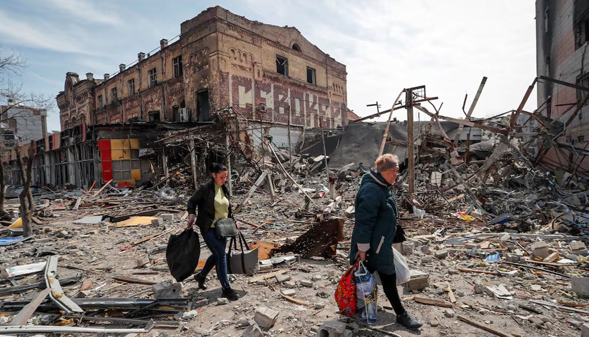 Residents carry their belongings near buildings destroyed in the course of Ukraine-Russia conflict, in the southern port city of Mariupol, Ukraine April 10, 2022. — Reuters