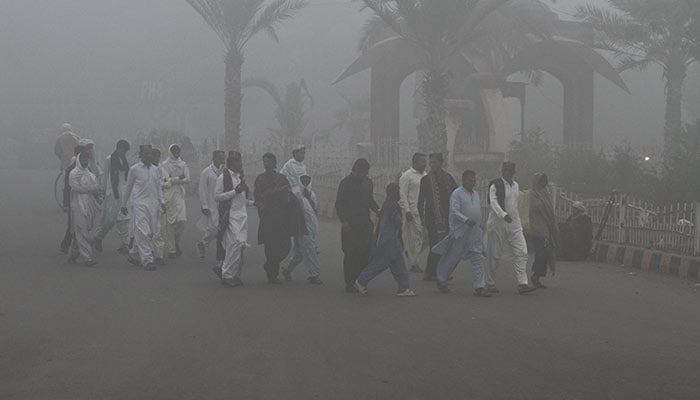 People walk amid thick smog along a road in Multan, Pakistan November 9, 2024. — Reuters