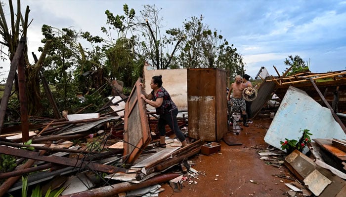 People collect belongings among the debris of a house after the passage of Hurricane Rafael in Alquizar, Artemisa province, Cuba on Nov. 7, 2024. — AFP