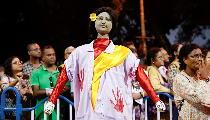 People stand behind an idol wearing a doctors coat as they attend a protest condemning the rape and murder of a trainee medic at a government-run hospital, in Kolkata, India, October 15, 2024. — Reuters