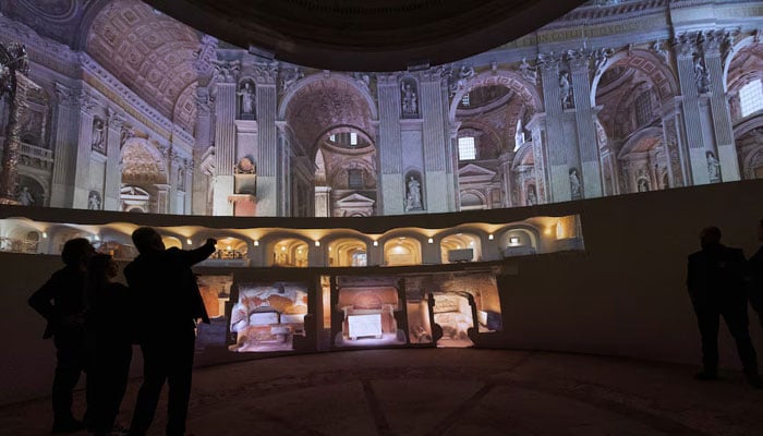 Visitors look at AI-generated images of the interiors of St. Peters Basilica as the Vatican presents a new AI-enhanced experience developed in collaboration with Microsoft for tourists visiting the Basilica at the Vatican, November 9, 2024. — Reuters