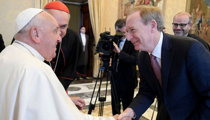 Pope Francis shakes hands with Microsoft Vice Chair and President Brad Smith at the St. Peters Basilica, as the Vatican presents a new AI-enhanced experience developed in collaboration with Microsoft for tourists visiting the Basilica, at the Vatican, November 11, 2024. — Reuters