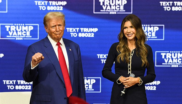 Donald Trump gestures next to South Dakota Governor Kristi Noem during a town hall campaign event in Oaks, Pennsylvania, US, October 14, 2024. — Reuters