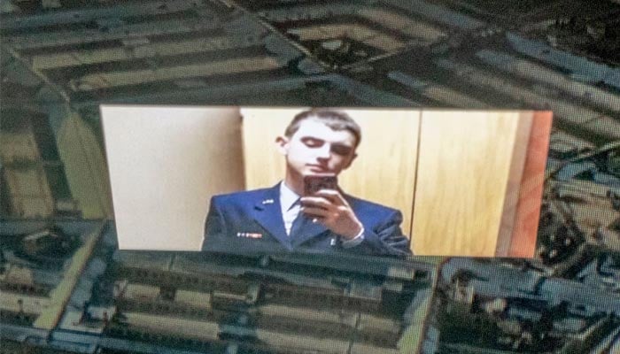 An undated image of the suspect, national guardsman Jack Teixeira, can be seen reflected in an image of the Pentagon in Washington, DC in this photo illustration created on April 13, 2023. — AFP