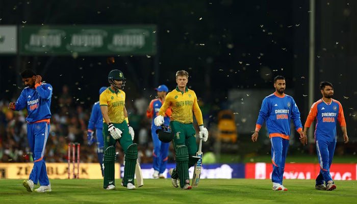 South Africas Ryan Rickelton and Reeza Hendricks walk off with India players as play is stopped due to flying ants on November 13, 2024. — Reuters