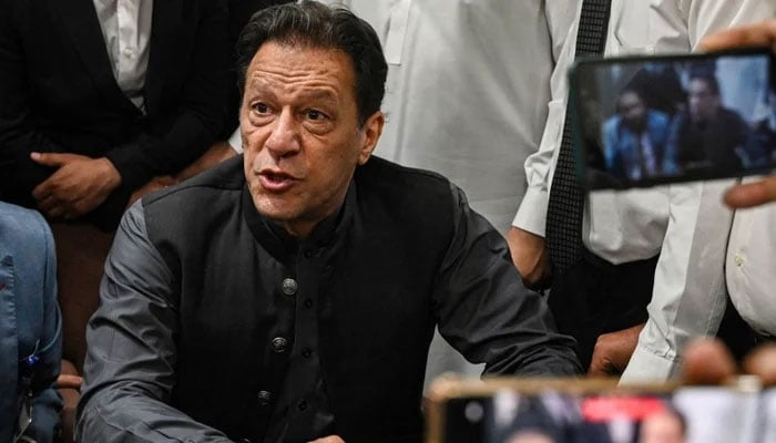 PTI founder Imran Khan speaks to journalists at a court in this undated photo. — AFP/File