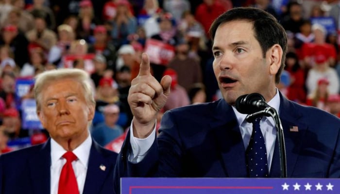 Donald Trump watches as US Senator Marco Rubio  speaks during a campaign rally on November 04, 2024 in Raleigh, North Carolina.— AFP