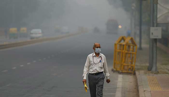 A man wearing a mask walks on a road amid a smoggy morning in New Delhi, India, November 13, 2024. — Reuters