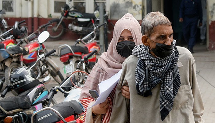 People wear masks to protect themselves against smog and air pollution while leaving a hospital in Lahore, November 13, 2024. — Reuters