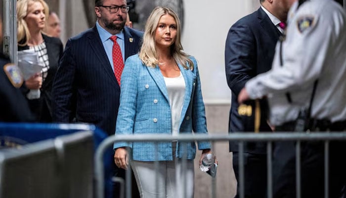 Karoline Leavitt, juru bicara mantan Presiden AS Donald Trump, berjalan ke ruang sidang di belakang Trump saat dia menghadiri persidangan pidana Trump di Mahkamah Agung Negara Bagian New York di New York, New York, Rabu, 29 Mei 2024. — Reuters