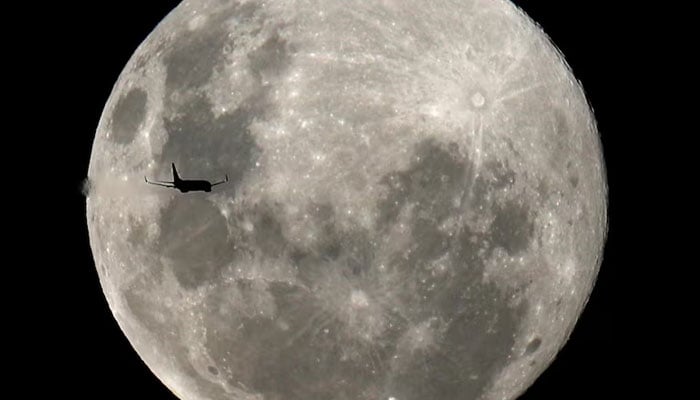 A plane is pictured in front of the full moon in Curitiba, Brazil, February 8, 2020. — Reuters