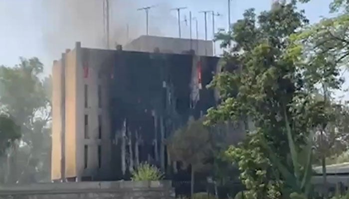 Smoke rises after alleged PTI protesters torched Radio Pakistan building in Peshawar on May 9, 2023. Screengrab via Geo News