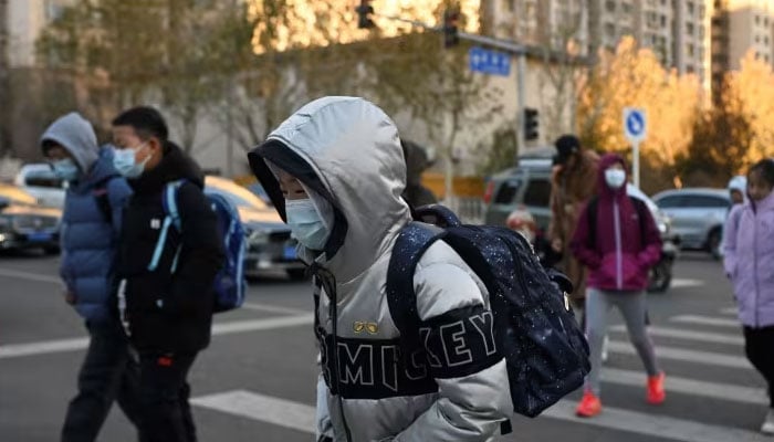 In this representational image, school students head for classes in Beijing on Nov 29, 2023, — AFP