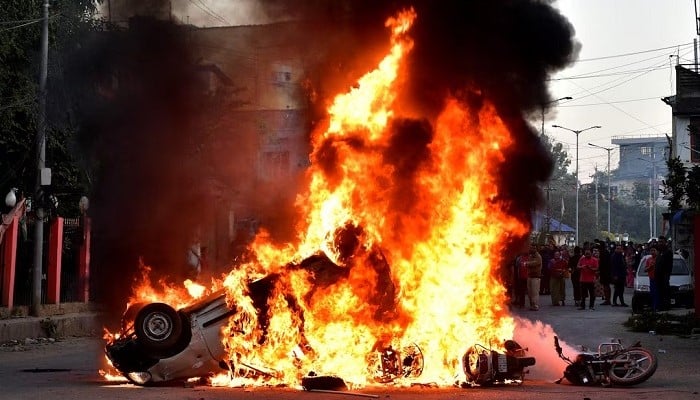 Vehicles burn as demonstrators stand during a protest against the recent killings, in Imphal West,Manipur, India, November 16, 2024. — Reuters