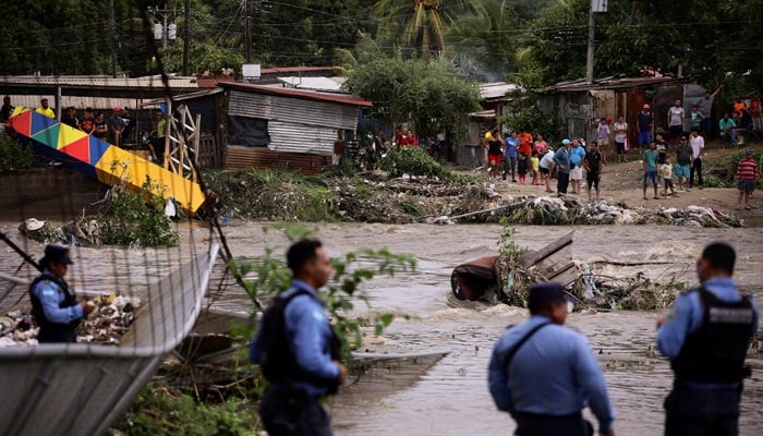 People watch as they stand near a bridge, destroyed by the Bermejo river current, during the aftermath of tropical storm Sara, in San Pedro Sula, Honduras, November 17, 2024. — Reuters