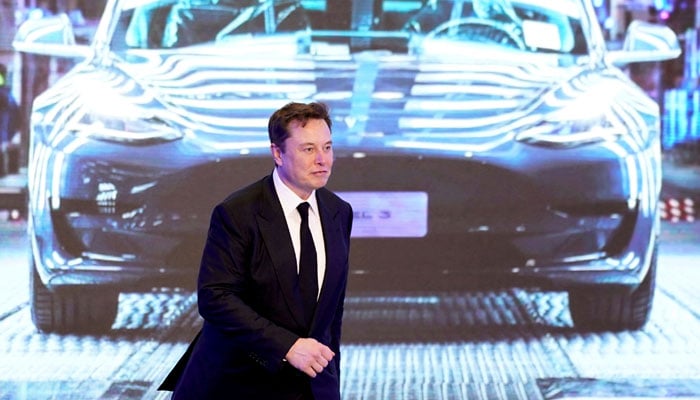 Tesla CEO Elon Musk walks next to a screen showing an image of Tesla Model 3 car during an opening ceremony for Tesla China-made Model Y program in Shanghai, China January 7, 2020. — Reuters