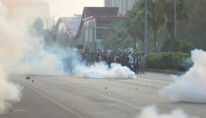 Supporters of the Pakistan Tehreek-e-Insaf (PTI) gather for an anti-government rally amid tear gas smoke fired by police to disperse them in Islamabad on October 4, 2024. —Reuters