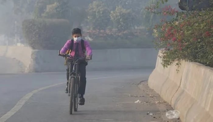 Student rides a bicycle to school amid dense smog in Lahore November 24, 2021. — Reuters