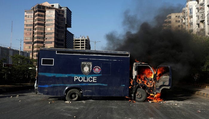 A police vehicle burns during a protest by the supporters of former Prime Minister Imran Khan after his arrest, in Karachi, May 9, 2023. — Reuters