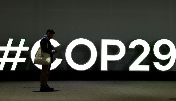 A man stands next to the logo of the COP29 United Nations climate change conference, in Baku, Azerbaijan, November 20, 2024. — Reuters