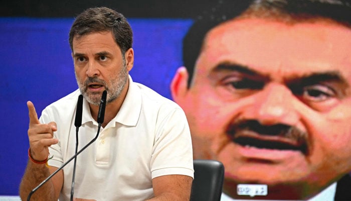 India´s Congress party leader Rahul Gandhi addresses a press conference against the backdrop of a picture of Indian industrialist Gautam Adani, at his party headquarters in New Delhi on November 21, 2024. — AFP