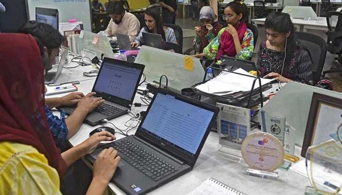 People work at their stations at the National Incubation Centre (NIC) in Lahore.  — AFP/File