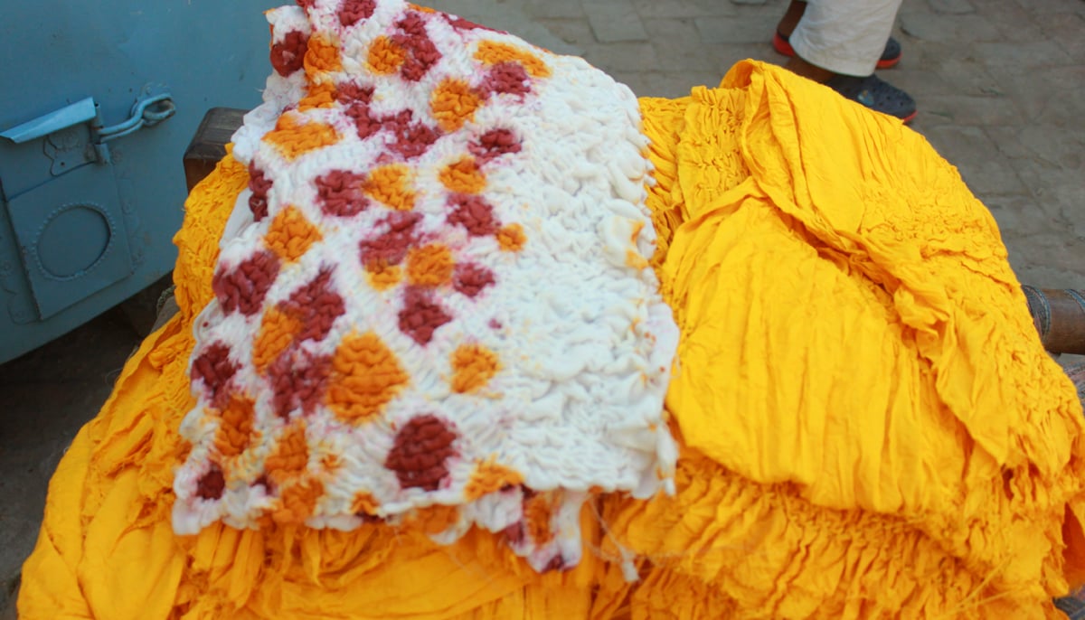 This photograph shows chunari fabric in yellow and white with red dye also in the mix. — Photo by author