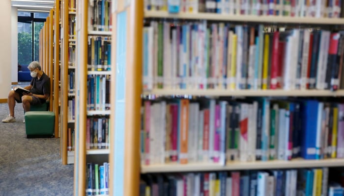 A representational image of a man reading a book in a library. — Reuters/file