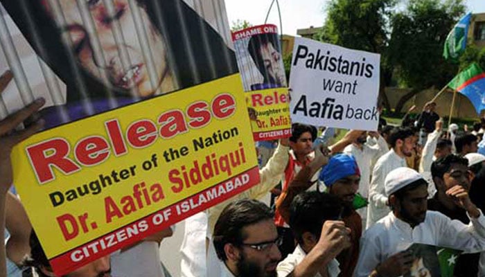 Jamaat-e-Islami activists carry photographs of Aafia Siddiqui during an anti-US protest in Islamabad. – AFP/File